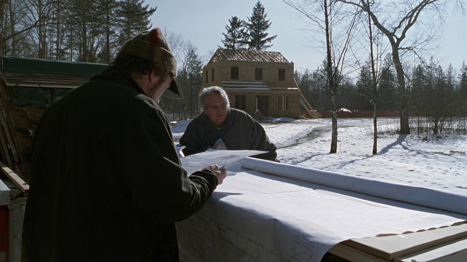 Builders reviewing electrical plans at a residential construction site in upstate New York