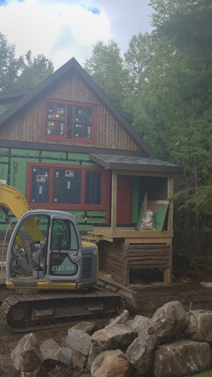 Camp on the Lake under construction — cedar siding, new porch, and the excavation that brought the service in